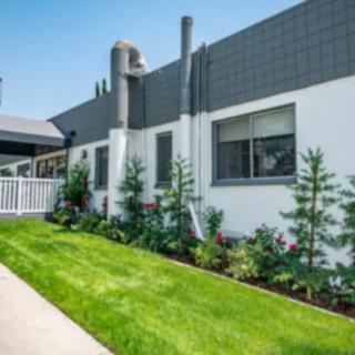 Modern building exterior with landscaped lawn and plants.