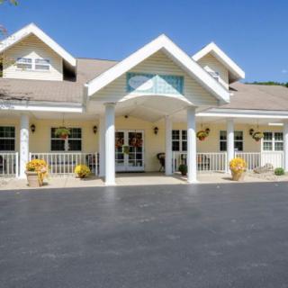 A residential building with a welcoming entrance, featuring columns and a porch.