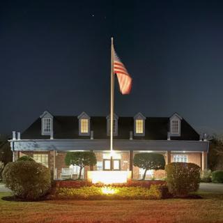 A well-lit building at night featuring a flag prominently displayed.