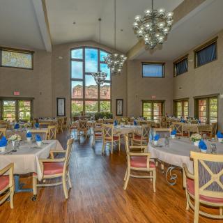 Spacious dining room with elegantly set tables and large windows.