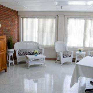 A bright living room with white furniture and large windows.