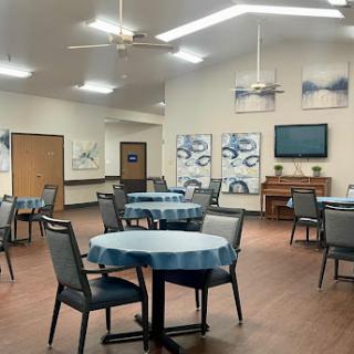 A spacious and inviting dining area featuring round tables and comfortable seating.