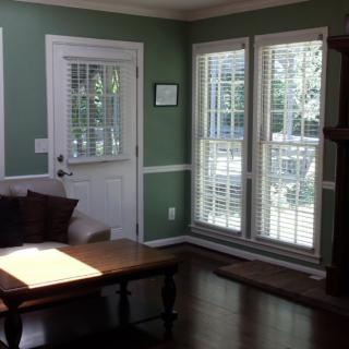 A cozy living room with large windows and a coffee table.