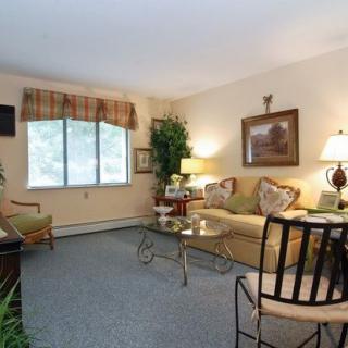 A cozy living room featuring a sofa, coffee table, and decorative lamps with art on the wall.