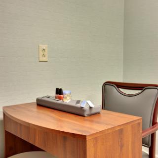 A simple workspace featuring a wooden desk and a chair, perfect for focused tasks.