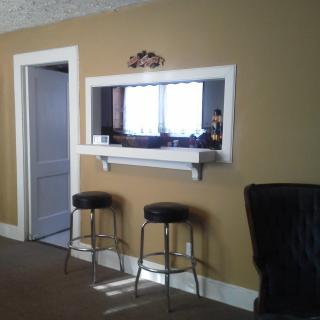 A cozy home interior featuring a pass-through window with two bar stools.