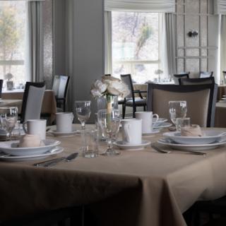 An elegantly set table in a quiet restaurant dining area.