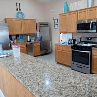 A well-equipped modern kitchen featuring granite countertops and stainless steel appliances.