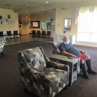 A person sitting in a chair in a well-lit living room.
