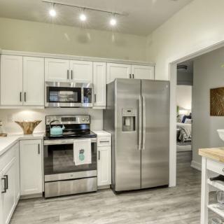 A modern kitchen with stainless steel appliances and white cabinets.