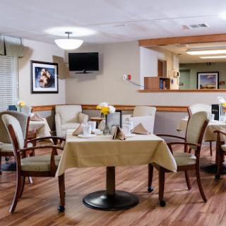 A cozy dining area featuring elegantly set tables and comfortable seating.