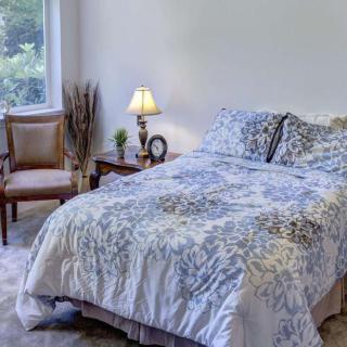 A cozy bedroom with a neatly made bed and elegant decor.