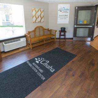 A clean and welcoming lobby area featuring a bench, floor mat, and air conditioner.