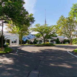 A scenic view of a church surrounded by trees with a clear blue sky.