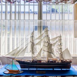 A detailed model of a sailing ship displayed indoors near a window.