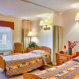 A cozy hotel room with twin beds and warm lighting.