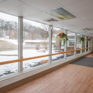 A bright corridor with large windows showcasing a snowy landscape outside.