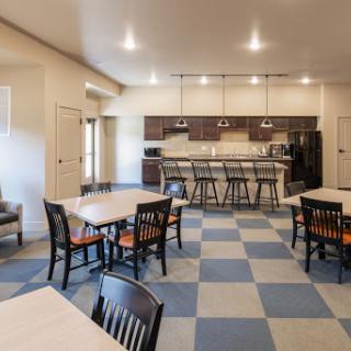 A modern kitchen and dining area featuring a spacious layout with tables, chairs, and bar seating.