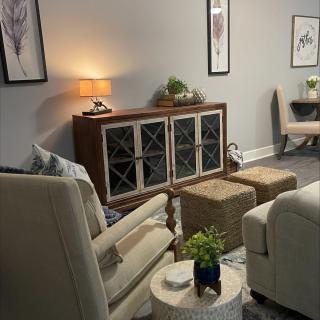 A cozy living room with modern decor, featuring comfortable seating and indoor plants.
