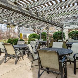 Outdoor patio area with seating under a pergola.