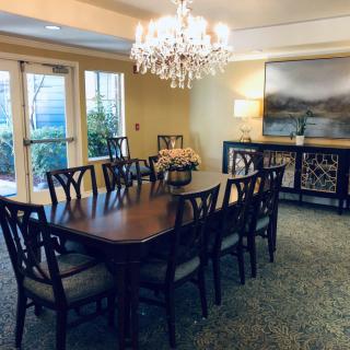 A beautifully decorated dining room with a large table, elegant chandelier, and stylish artwork on the wall.