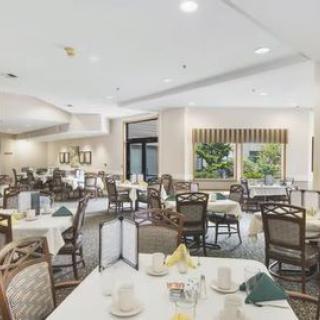 A spacious dining room with neatly arranged tables and chairs, featuring a bright and welcoming atmosphere.