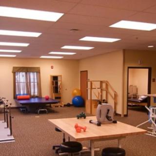 A spacious rehabilitation center equipped with exercise and therapy tools.