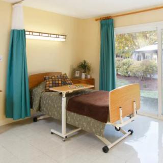 A clean and organized hospital room with a single bed and large window.