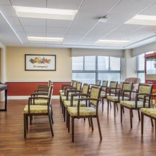 A meeting room with neatly arranged chairs and large windows.
