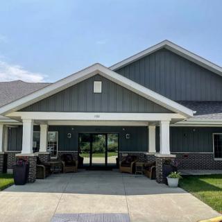A modern residential building with a prominent entrance and a well-maintained front yard.