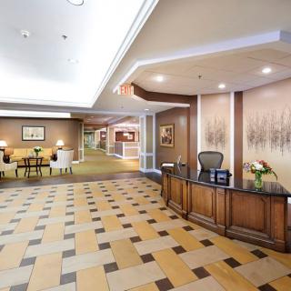 A hotel lobby with a reception desk and seating area.