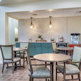 A cozy cafe seating area with tables and chairs, featuring soft lighting and a relaxed atmosphere.