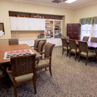 A conference room with wooden tables, upholstered chairs, and built-in bookshelves.