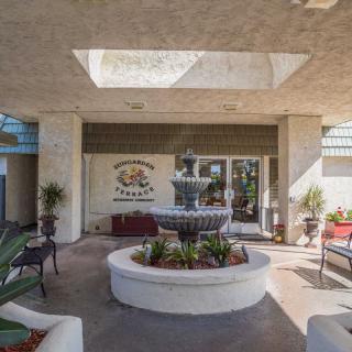 The entrance of a hotel featuring a decorative fountain surrounded by plants.