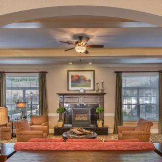 A cozy living room with a central fireplace and elegant furniture arrangement.