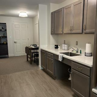 A modern kitchen area featuring wooden cabinets and a minimalist design.