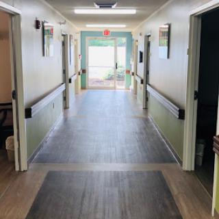 A long hallway leading to an exit, showcasing well-lit walls and a modern flooring design.