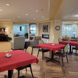 A cozy dining area with red tablecloths and neatly arranged tables and chairs.