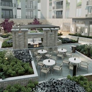 A serene outdoor garden space featuring modern seating arrangements and greenery in an apartment complex.