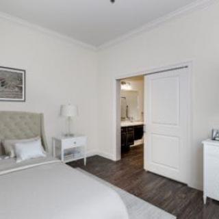 A modern, minimalist bedroom with white walls and elegant furniture.