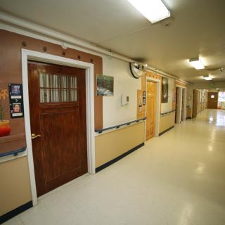 A view of a school hallway with multiple doors and bright lighting.