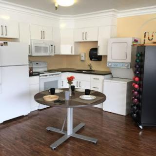 A modern kitchen featuring sleek appliances and a round dining table set for two.