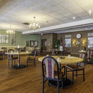 A cozy dining area with round tables and chandeliers, featuring a warm and inviting ambiance.