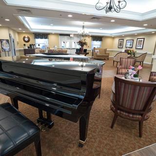 A cozy lobby featuring a grand piano with comfortable seating and elegant decor.