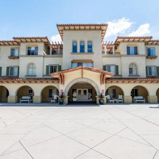 A three-story building with an arched entrance and Mediterranean-style architecture.