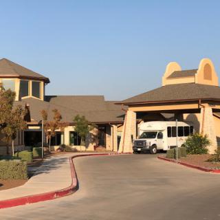 A view of a building with a bus parked in front, set against a clear sky.