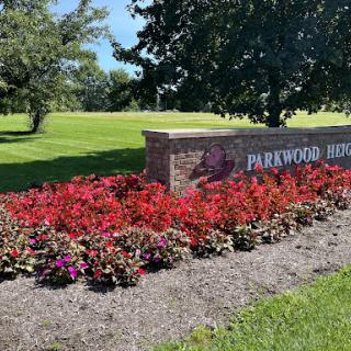 A beautiful park entrance surrounded by vibrant flowers.