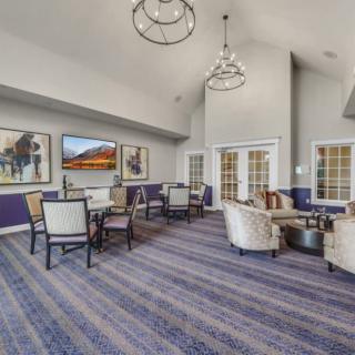 A spacious and elegantly decorated lounge area with comfortable seating and modern artwork adorning the walls.