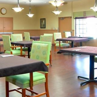 An empty dining room with neatly arranged tables and chairs.