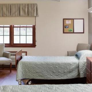 A neatly arranged hospital room with twin beds and comfortable seating.